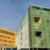 TYKS Kompassisairaalan rakennukset. Oikealla vihreä rakennus, jossa lukee TYKS. Vasemmalla keltainen rakennus. Taustalla sininen taivas